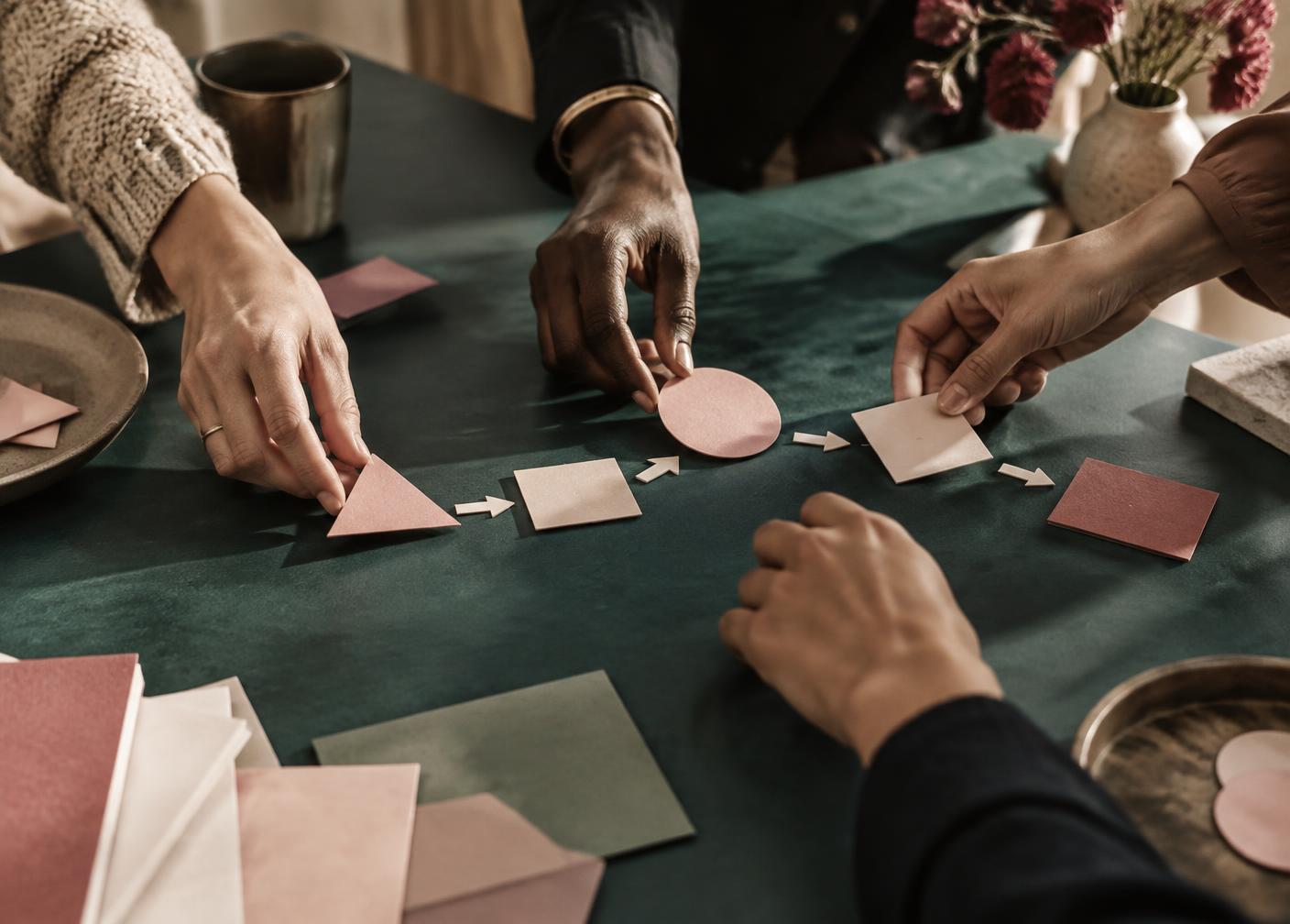 Hands arranging shapes into a shared sequence